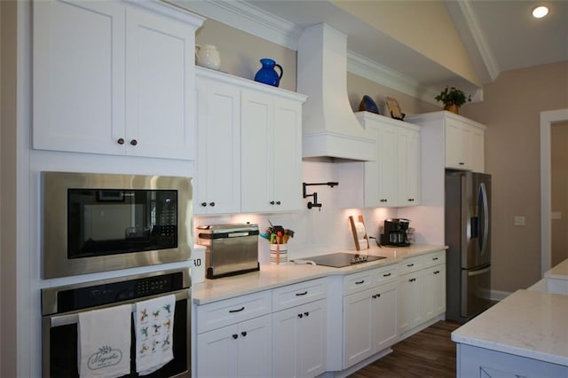 kitchen with black appliances, white cabinetry, ornamental molding, and vaulted ceiling