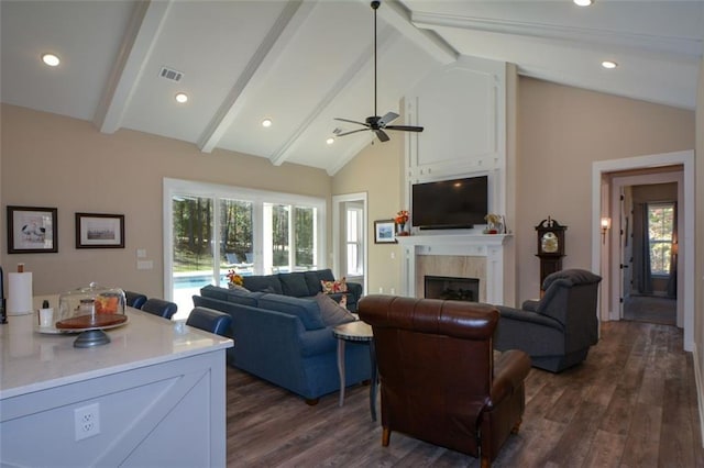 living room with high vaulted ceiling, a tile fireplace, ceiling fan, beamed ceiling, and dark hardwood / wood-style flooring