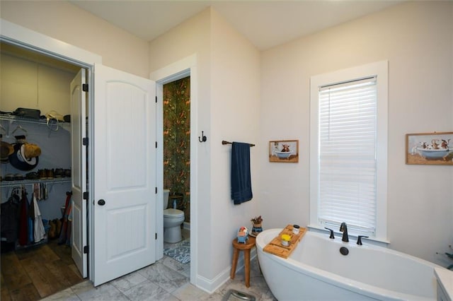 bathroom with toilet and a tub