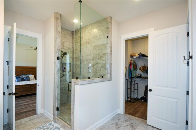 bathroom featuring ceiling fan, an enclosed shower, and wood-type flooring