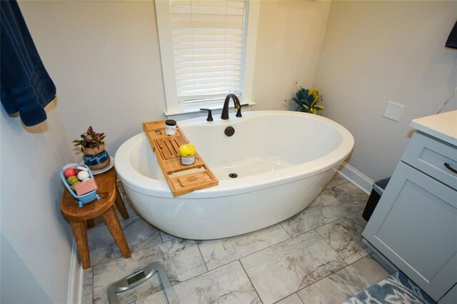 bathroom featuring a washtub and vanity