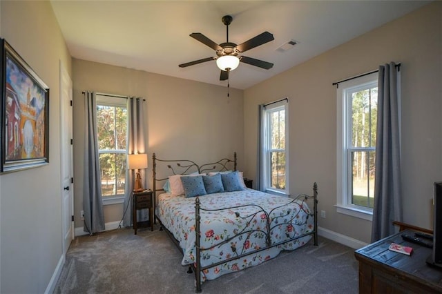 carpeted bedroom featuring ceiling fan and multiple windows