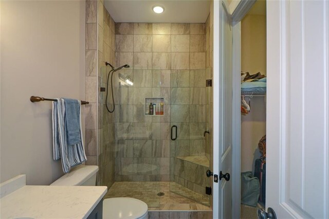 bathroom featuring vanity, toilet, and an enclosed shower