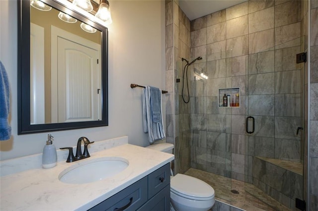 bathroom with vanity, an enclosed shower, and toilet