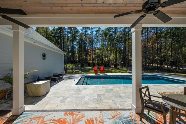 view of swimming pool featuring ceiling fan and a patio