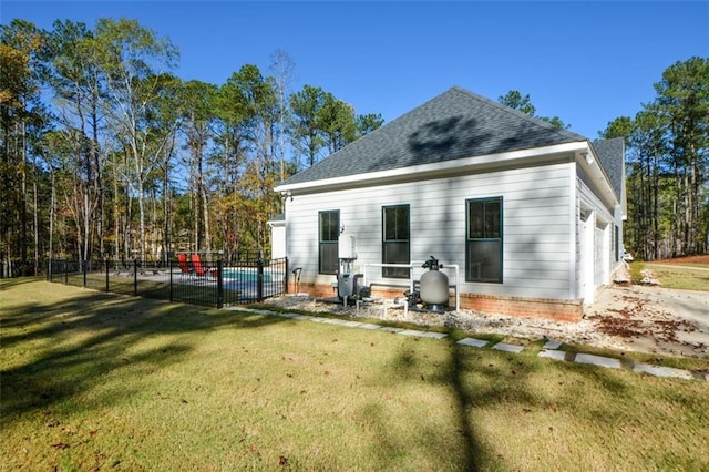 rear view of house featuring a lawn and a garage