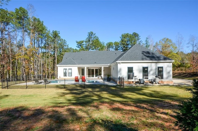 rear view of house featuring a patio area, a yard, and a fenced in pool