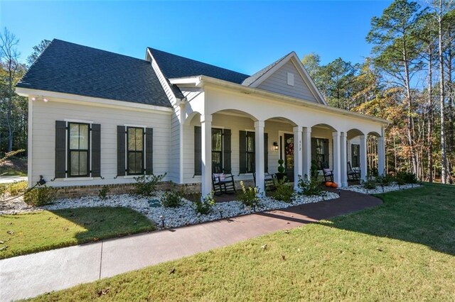 view of front of property featuring covered porch and a front yard