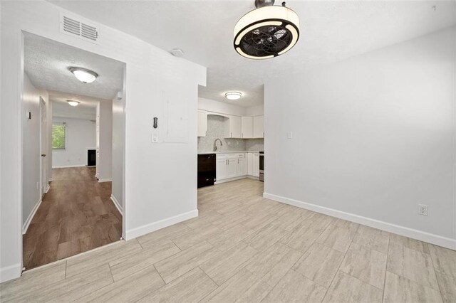 kitchen with decorative backsplash, sink, white cabinetry, and stainless steel appliances