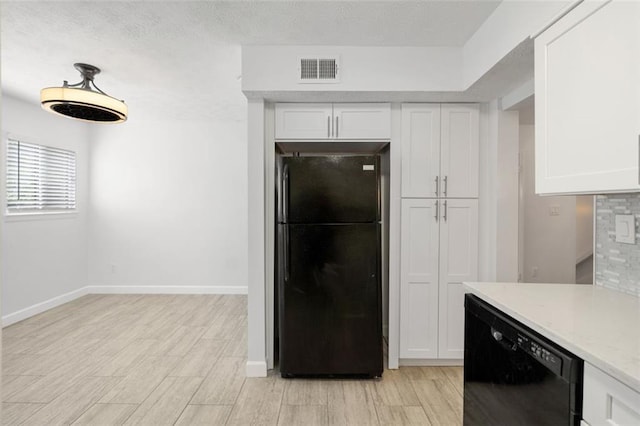 kitchen featuring tasteful backsplash, white cabinets, and black appliances