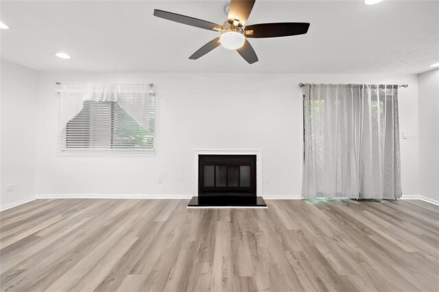 unfurnished living room featuring light hardwood / wood-style flooring and ceiling fan