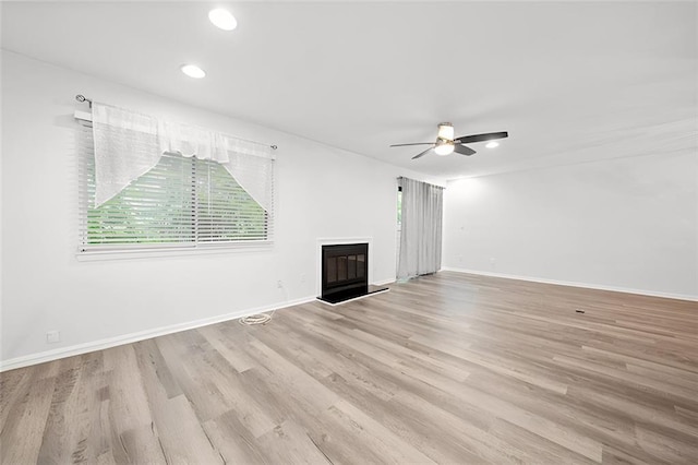 unfurnished living room featuring ceiling fan and light hardwood / wood-style floors