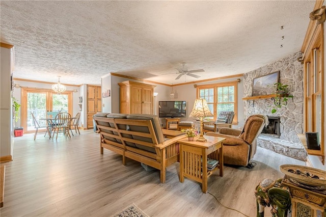 5848 Kingswood Ct, Norcross, GA 30093 - living room with light wood-style flooring, crown molding, ceiling fan, a textured ceiling, and a stone fireplace