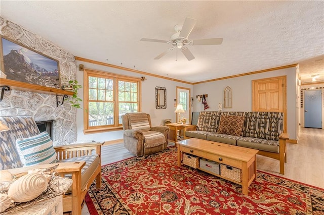 5848 Kingswood Ct, Norcross, GA 30093 - living room featuring crown molding, ceiling fan, wood finished floors, a textured ceiling, and a stone fireplace