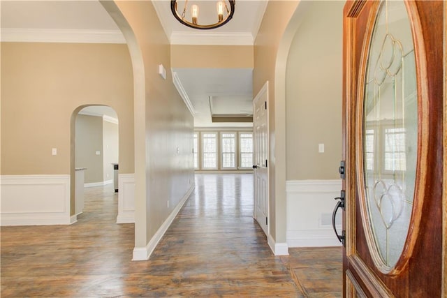 entryway featuring dark wood-style floors, a wainscoted wall, and crown molding