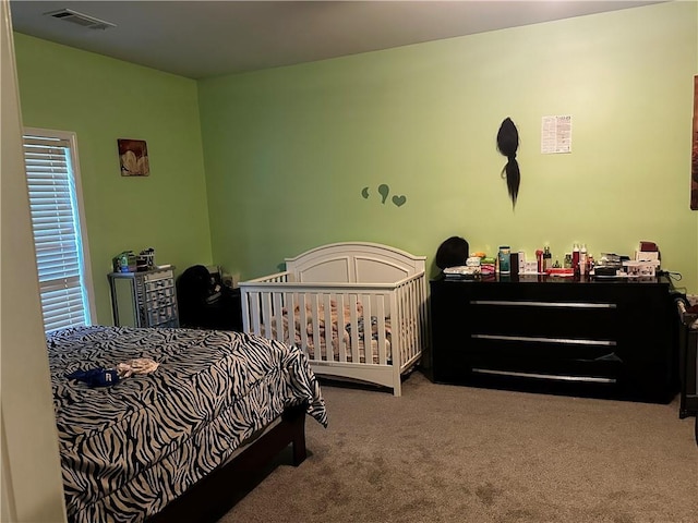 carpeted bedroom with a nursery area