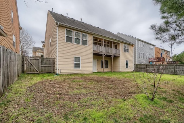 rear view of house with a balcony and a lawn