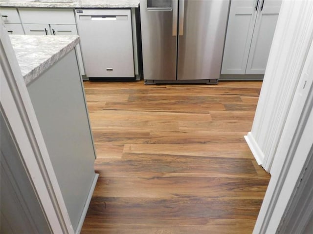 893 Andrews Dr, Conyers, GA 30012 - kitchen with appliances with stainless steel finishes, light wood-type flooring, and light stone countertops