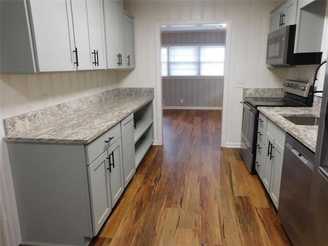 893 Andrews Dr, Conyers, GA 30012 - kitchen featuring appliances with stainless steel finishes, dark wood-style floors, light stone counters, and gray cabinetry