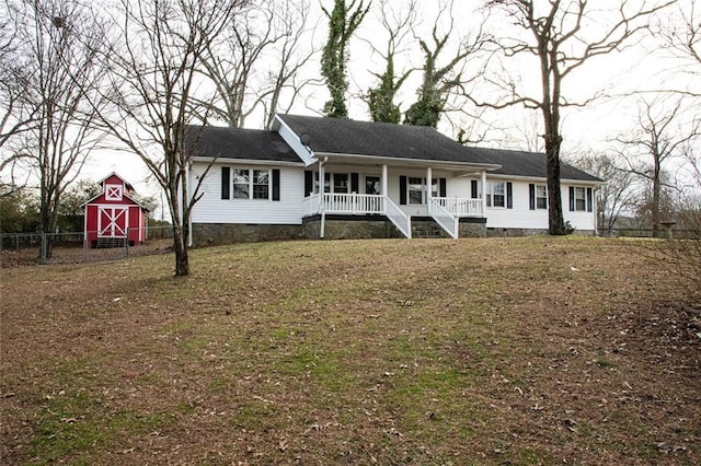 ranch-style house with an outbuilding, a front lawn, and a porch