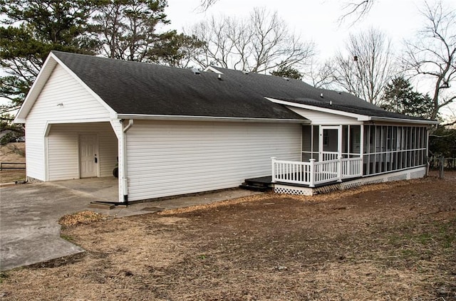 rear view of house featuring a deck, a sunroom, and a carport