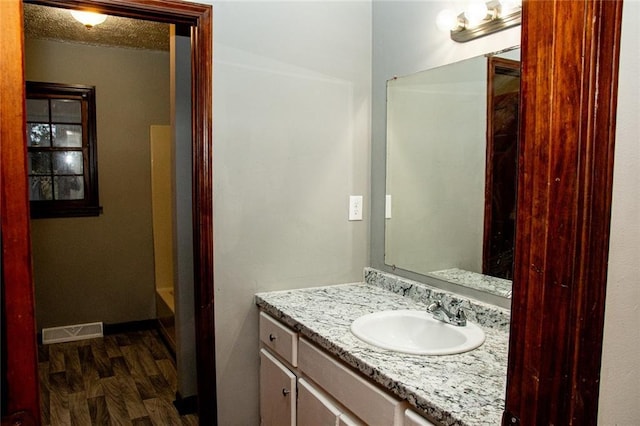 bathroom featuring a tub to relax in, vanity, and hardwood / wood-style flooring