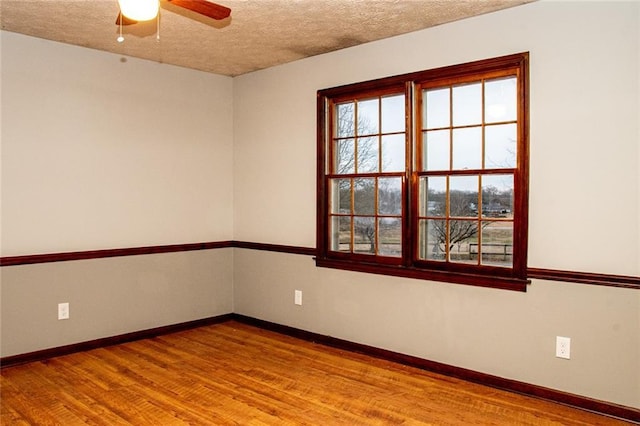 unfurnished room with ceiling fan, a textured ceiling, and hardwood / wood-style floors