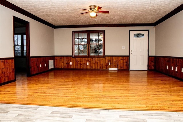 spare room featuring hardwood / wood-style flooring, a textured ceiling, and crown molding