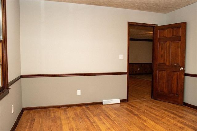 unfurnished room featuring a textured ceiling and hardwood / wood-style flooring