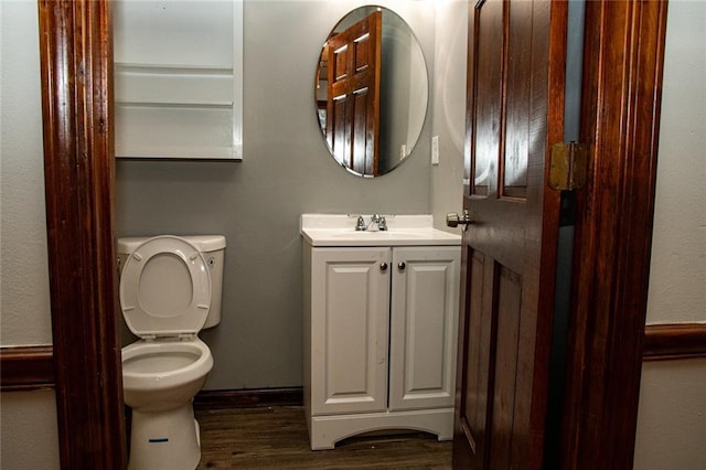 bathroom featuring wood-type flooring, toilet, and vanity