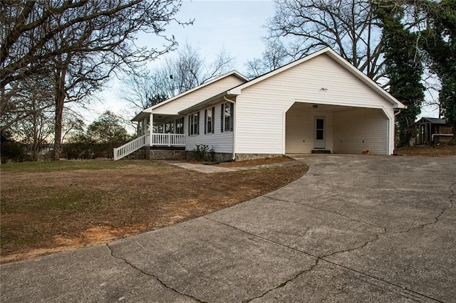 ranch-style home featuring covered porch, a front yard, and a carport