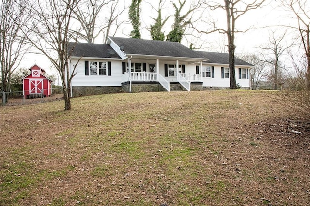 ranch-style house featuring a front lawn, a shed, and a porch