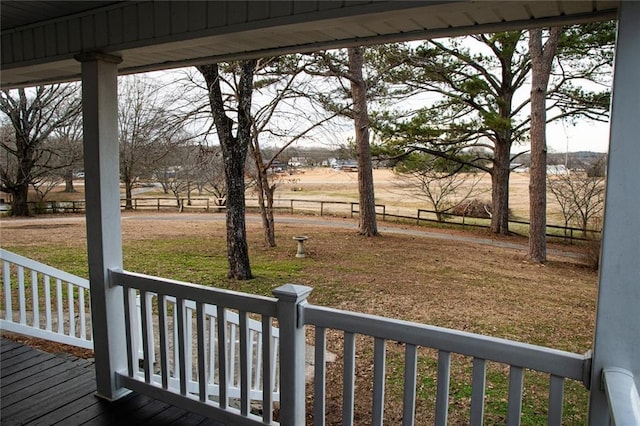 wooden deck featuring a rural view and a yard