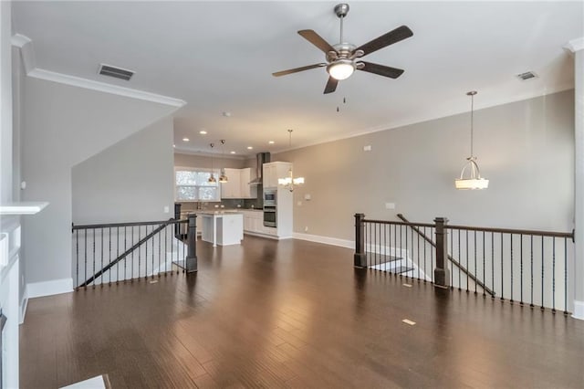 living room with crown molding, dark wood-type flooring, and ceiling fan with notable chandelier