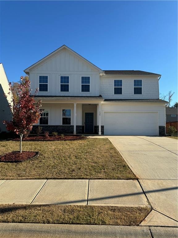 136 Paulownia Cir, Mcdonough, GA 30253 - view of front facade with a garage, board and batten siding, concrete driveway, and a front lawn