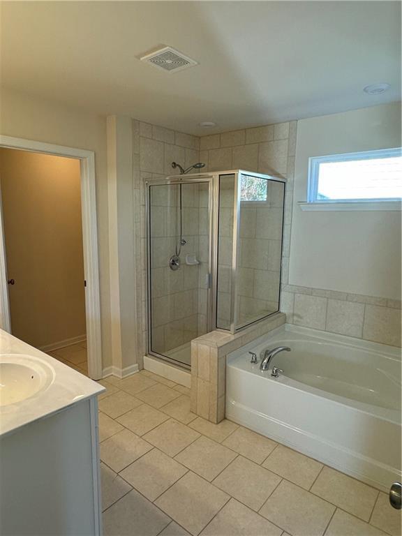 136 Paulownia Cir, Mcdonough, GA 30253 - full bath featuring tile patterned floors, a garden tub, a shower stall, and vanity