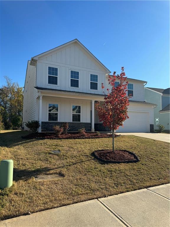 136 Paulownia Cir, Mcdonough, GA 30253 - view of front of property featuring board and batten siding, an attached garage, concrete driveway, and a front yard