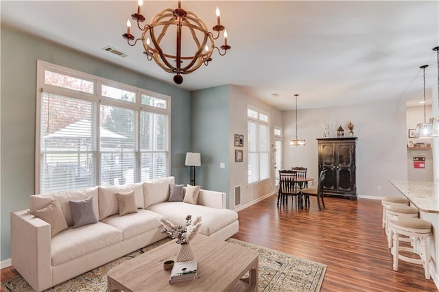 living room featuring dark hardwood / wood-style flooring and an inviting chandelier