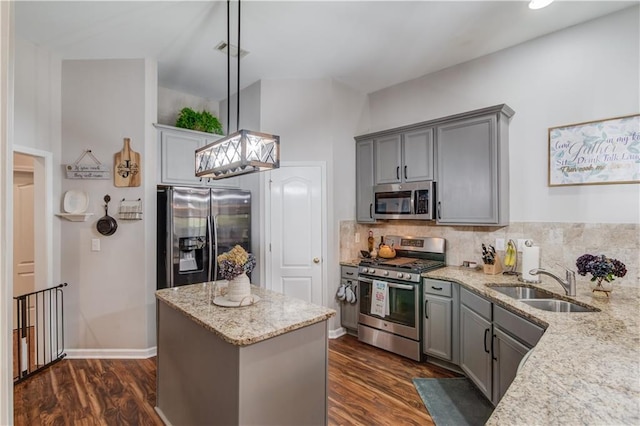 kitchen with dark hardwood / wood-style flooring, stainless steel appliances, sink, pendant lighting, and a center island