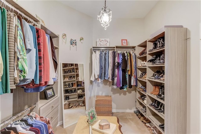 walk in closet with a chandelier and light colored carpet