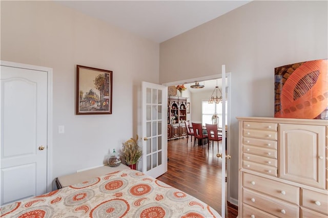 bedroom with french doors, dark hardwood / wood-style floors, and a notable chandelier