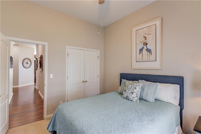 bedroom with ceiling fan, wood-type flooring, and a closet