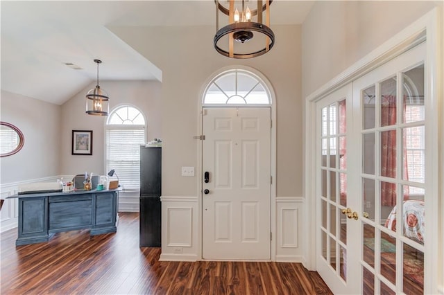 foyer entrance featuring dark hardwood / wood-style flooring, a healthy amount of sunlight, and vaulted ceiling