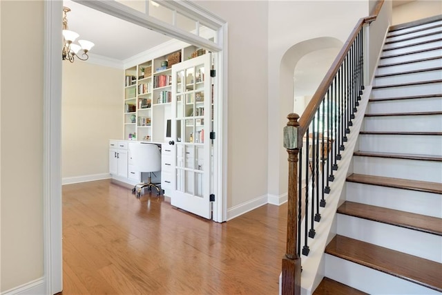 372 Abbington Way, Clarkesville, GA 30523 - staircase featuring arched walkways, baseboards, wood finished floors, a chandelier, and ornamental molding