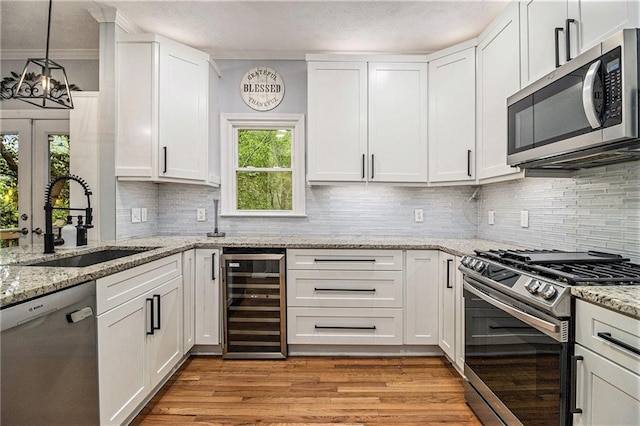 4272 Glenlake Dr NW, Kennesaw, GA 30144 - kitchen with beverage cooler, stainless steel appliances, a sink, white cabinetry, and light wood finished floors