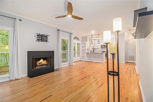 4272 Glenlake Dr NW, Kennesaw, GA 30144 - unfurnished living room with ornamental molding, light wood finished floors, a fireplace with flush hearth, ceiling fan, and baseboards