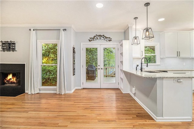 4272 Glenlake Dr NW, Kennesaw, GA 30144 - kitchen featuring white cabinetry, light wood-style flooring, a sink, french doors, and a fireplace with flush hearth