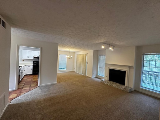 1101 Lenox Way NE Unit 1101, Atlanta, GA 30324 - unfurnished living room featuring carpet, a chandelier, a textured ceiling, a fireplace with raised hearth, and baseboards