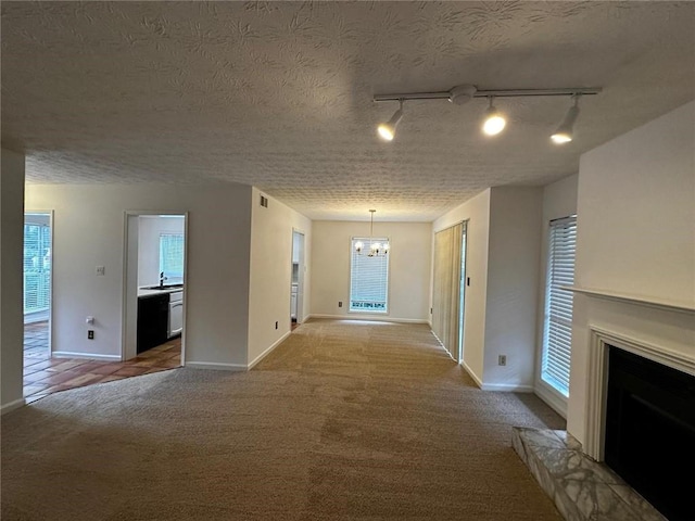 1101 Lenox Way NE Unit 1101, Atlanta, GA 30324 - hallway featuring a chandelier, rail lighting, carpet floors, baseboards, and a textured ceiling