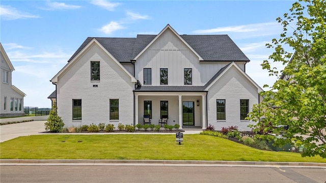 213 Brogans Blf, Ball Ground, GA 30107 - modern farmhouse style home with board and batten siding, a front lawn, a porch, a shingled roof, and brick siding